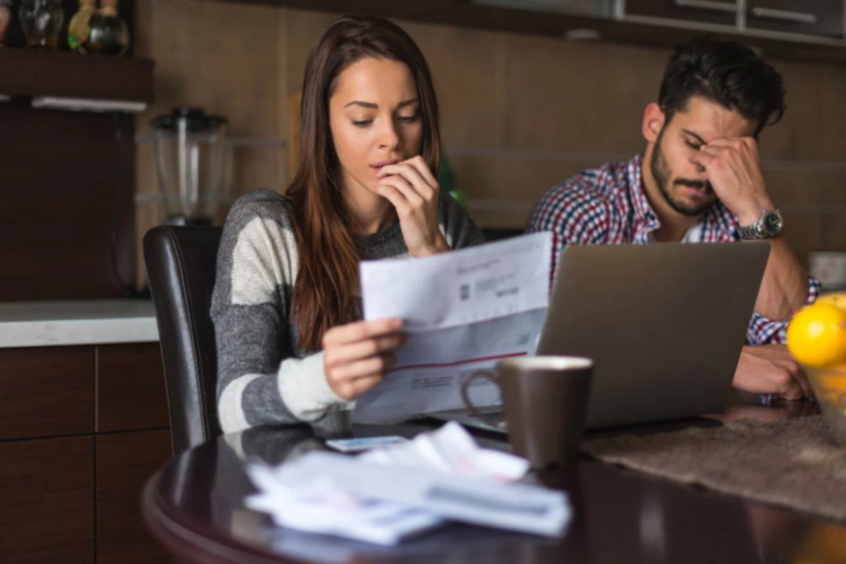 uomo e donna preoccupati mentre leggono le bollette